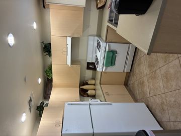 Selma apartment for rent - A kitchen with a white fridge and wooden cabinets.