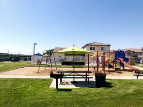 Orange Cove apartment for rent - A playground with a green umbrella and a slide.