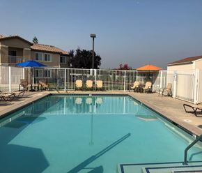 Orange Cove apartment for rent - A swimming pool with a blue umbrella and orange umbrella in the background.