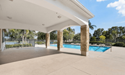 Naples apartment for rent - A pool area with a white roof and a fence in the background.