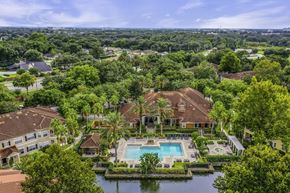Sanford apartment for rent - A large house with a pool surrounded by trees.