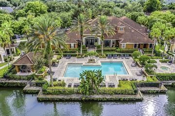 Sanford apartment for rent - A large house with a pool in the middle of a water body surrounded by greenery.