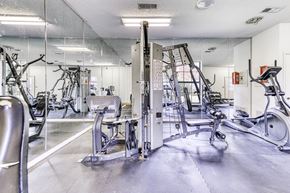 Pensacola condo for rent - A gym with a variety of equipment including treadmills, weights, and exercise machines.