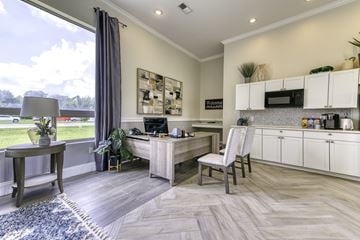 Pensacola condo for rent - A modern kitchen with a desk and chair in the middle of the room.