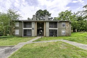 Pensacola apartment for rent - A two-story apartment building with a garage door on the first floor.