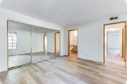 Las Vegas apartment for rent - Bedroom with hardwood floors and large mirror at Pacific Harbors Sunrise Apartments, Las Vegas