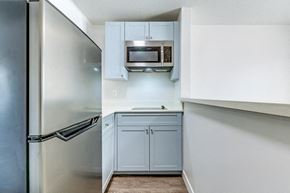San Diego apartment for rent - a kitchen with white cabinets and a stainless steel refrigerator