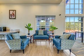 San Diego apartment for rent - a living room with blue couches and chairs and a window
