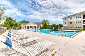 Panama City apartment for rent - A pool area with sun loungers and a building in the background.