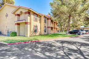 Las Vegas apartment for rent - a beige apartment building with cars parked in front of it