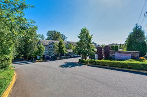 Seattle apartment for rent - a street view of a house with a driveway and trees