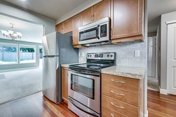 Tacoma apartment for rent - a kitchen with stainless steel appliances and wooden cabinets