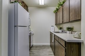 Auburn apartment for rent - A kitchen with a refrigerator, wooden cabinets, and a sink.