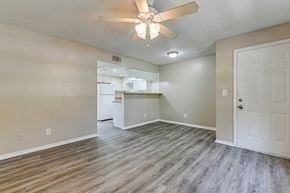 Tampa apartment for rent - A room with a ceiling fan and wooden flooring. at Green Oaks Apartments, Apartments, Tampa, FL