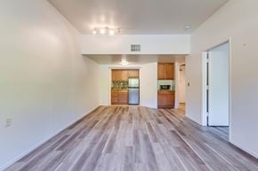 Poway apartment for rent - A spacious room with wooden flooring and white walls.