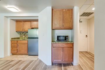 Poway apartment for rent - A kitchen with wooden cabinets and a stainless steel refrigerator.