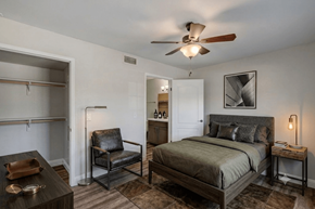 Henderson apartment for rent - A bedroom with a bed, chair, and a ceiling fan.