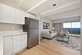 Stockton apartment for rent - A modern kitchen with white cabinets and a black refrigerator.