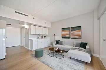 Stockton apartment for rent - A living room with a white couch and a green ottoman.