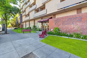 Stockton apartment for rent - A red bench sits on a sidewalk in front of a building named Madison Tower.