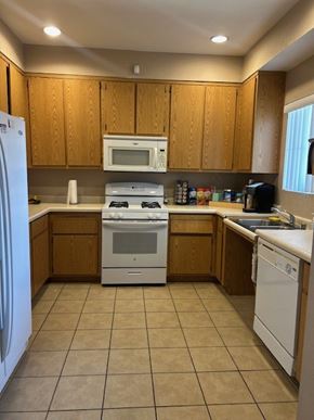 Orange Cove apartment for rent - A kitchen with wooden cabinets and white appliances.