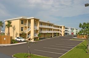 Key West apartment for rent - A car is parked in a parking lot in front of a building.