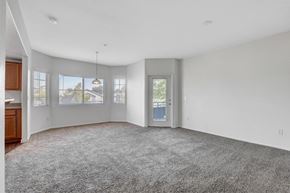 Henderson apartment for rent - A spacious room with a grey carpet and a door on the right side.