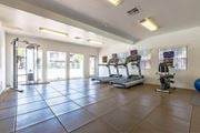 Las Vegas apartment for rent - A spacious gym with treadmills, elliptical machines, and a blue exercise ball.