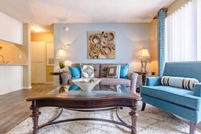 Las Vegas apartment for rent - Living room with gray sofa and turquoise accent chairs at Playa Vista Apartments, Nevada