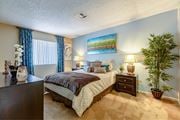 Las Vegas apartment for rent - A bedroom with a bed, nightstand, and a potted plant.