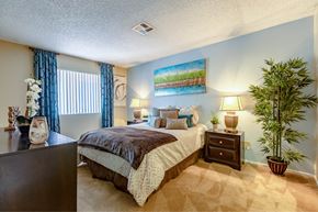 Las Vegas apartment for rent - A bedroom with a bed, nightstand, and a potted plant.