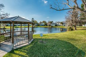 Daytona Beach apartment for rent - A gazebo sits in a grassy area next to a lake.