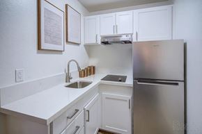 Mountain View apartment for rent - A kitchen with white cabinets and a stainless steel refrigerator.