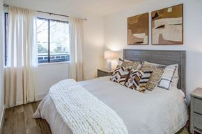 Mountain View apartment for rent - A bedroom with a large bed and two abstract paintings on the wall.