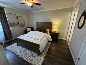 Spartanburg apartment for rent - A bedroom with a large bed and a ceiling fan.