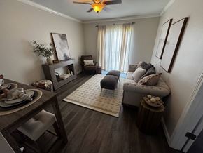 Spartanburg apartment for rent - A living room with a grey couch, a wooden table, and a ceiling fan.