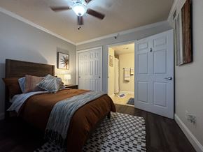 Spartanburg apartment for rent - A bedroom with a bed, a ceiling fan, and a rug.