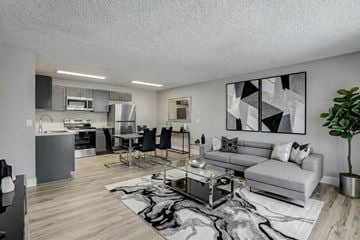 Las Vegas apartment for rent - A modern living room with a grey couch, a coffee table, and a large abstract painting on the wall.