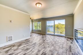 Seatac apartment for rent - an empty living room with a sliding glass door to a balcony
