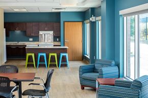 Saint Paul apartment for rent - a lounge area with chairs and tables and a kitchen with a counter