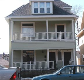 Minneapolis apartment for rent - A two story house with a balcony and a car parked in front.