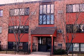 Minneapolis apartment for rent - A red brick building with a black gate in front.