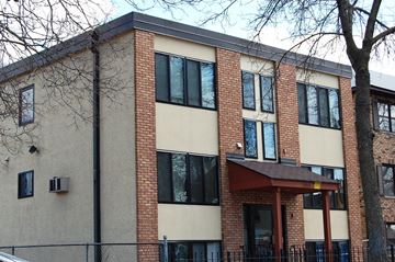 Minneapolis apartment for rent - A building with a brown roof and a tree in front.