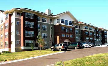 Minneapolis apartment for rent - A large apartment complex with a parking lot in front.