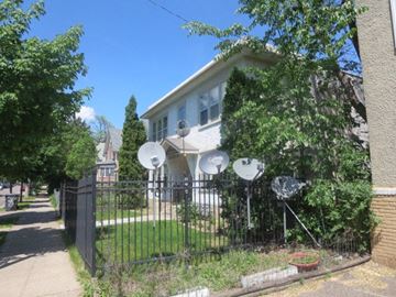 Minneapolis apartment for rent - A house with a black fence and satellite dishes on the roof.
