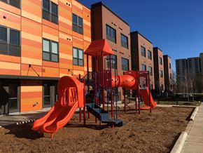 Minneapolis apartment for rent - A playground with a red slide in front of a building.