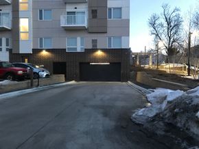 Hopkins apartment for rent - A car is parked in front of a building with a black garage door.