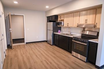Saint Paul apartment for rent - A kitchen with black appliances and wooden cabinets.