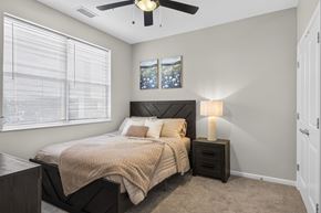 Traverse City apartment for rent - A bedroom with a bed, nightstand, and a ceiling fan.