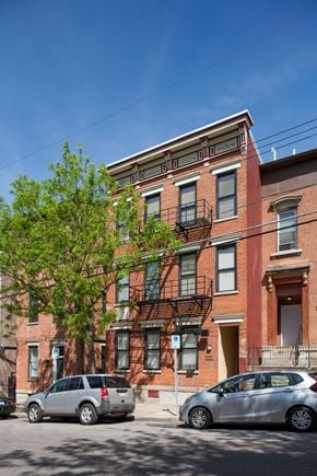Cincinnati apartment for rent - A red brick building with a tree in front of it.